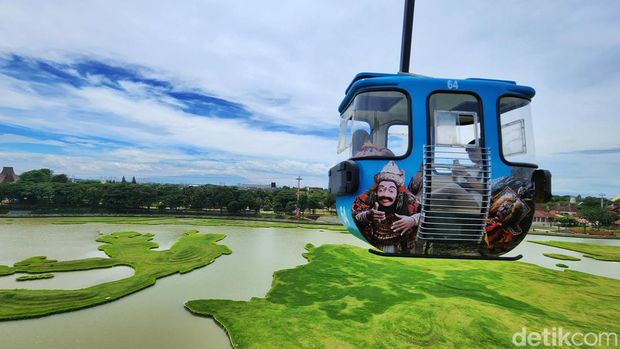 Pengunjung TMII melihat pemandangan atas dari dalam wahana kereta gantung di TMII, Jakarta Timur, Minggu (20/11/2022).