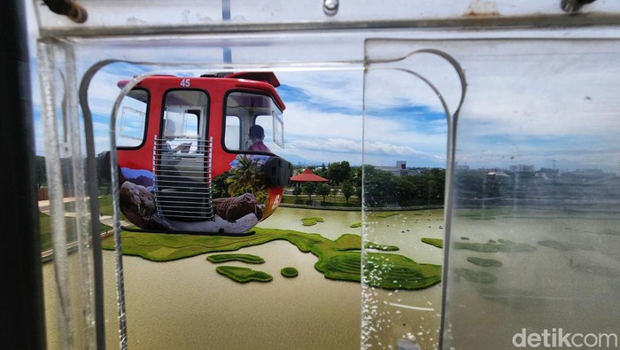 Pengunjung TMII melihat pemandangan atas dari dalam wahana kereta gantung di TMII, Jakarta Timur, Minggu (20/11/2022).