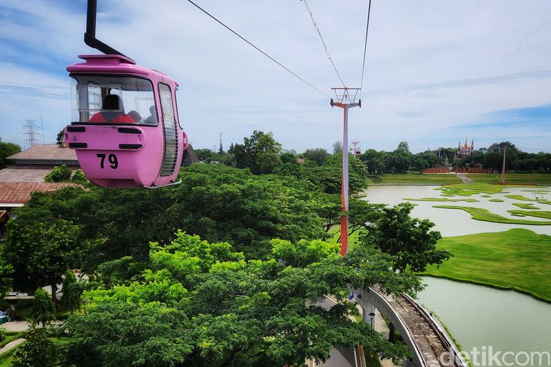 Pengunjung TMII melihat pemandangan atas dari dalam wahana kereta gantung di TMII, Jakarta Timur, Minggu (20/11/2022).