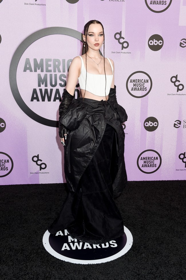 Dove Cameron menunjukkan sisi stylish-nya dengan gaun hitam-putih karya Marc Jacobs. Gaun tersebut terdiri dari crop top bergaya korset dan jaket yang diikat sehigga menyatu dengan rok. (Foto: Variety via Getty Images/Gilbert Flores)