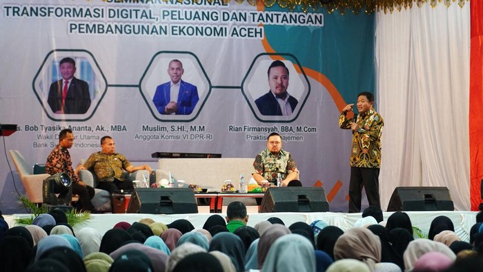 Wakil Direktur Utama Bank Syariah Indonesia BSI Bob Tyasika Ananta (kiri pertama) saat memberikan bantuan beasiswa Program BSI Scholarship Inspirasi kepada perwakilan mahasiswa Universitas Malikussaleh disaksikan oleh Rektor Universitas Malikussaleh   Dr. H. Herman Fithra, ST., MT., IPM., ASEAN.Eng. (kanan kedua) dan Anggota Komisi VI DPR-RI Muslim (kanan pertama) di GOR ACC Universitas Malikussaleh, Lhokseumawe, Aceh Utara (21/11).
