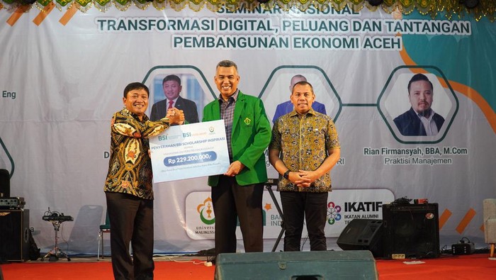BSI Terus Genjot Transformasi Digital di Aceh Wakil Direktur Utama Bank Syariah Indonesia BSI Bob Tyasika Ananta (kiri pertama) saat memberikan bantuan beasiswa Program BSI Scholarship Inspirasi kepada perwakilan mahasiswa Universitas Malikussaleh disaksikan oleh Rektor Universitas Malikussaleh Dr. H. Herman Fithra, ST., MT., IPM., ASEAN.Eng. (kanan kedua) dan Anggota Komisi VI DPR-RI Muslim (kanan pertama) di GOR ACC Universitas Malikussaleh, Lhokseumawe, Aceh Utara (21/11).
