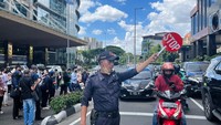 Petugas membawa bendera untuk menunjukkan titik kumpul yang aman.