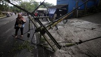 Terlihat sebuah tiang listrik roboh menimpa jalan.