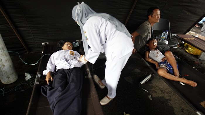Korban Gempa Cianjur Dirawat di Tenda Darurat Korban gempa bumi mendapat perawatan di tenda darurat RSUD Cimacan, Kabupaten Cianjur, Jawa Barat, Senin (21/11/2022). Pemerintah Kabupaten Cianjur menyatakan hingga pukul 18.17 WIB jumlah korban jiwa akibat gempa bumi sebanyak 56 orang dan korban luka mencapai 700 orang. ANTARA FOTO/Yulius Satria Wijaya/tom.