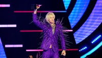 Ia menggunakan jas berwarna biru gelap dengan banyaknya duri yang menempel. Ia juga memanjangkan rambut blonde nya itu.  Foto: Getty Images/Kevin Winter