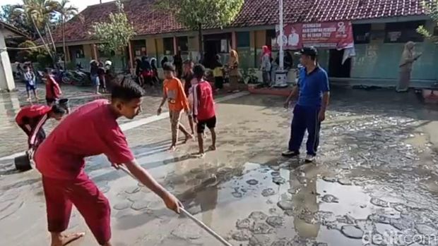 Para siswa kerja bakti membersihkan sekolah yang terendam banjir di Brebes, Sabtu (19/11/2022) lalu. Foto diambil Senin (21/11).