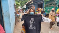 Usai melakukan blusukan, Jokowi sempat membagikan kaus kepada para pengunjung di sekitar Pasar Malangjiwan. Kaus tersebut dibagikan oleh Paspampres, dan menjadi rebutan warga. (Foto: Agil Trisetiawan Putra/detikJateng)