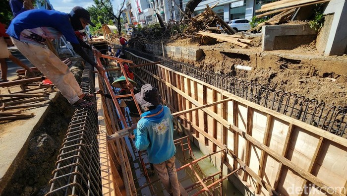 Para pekerja menyelesaikan proyek pembuatan saluran air di Jalan Sukarjo Wirjopranoto, Sawah Besar, Jakarta Pusat, Senin (21/11/2022). Saluran air tersebut menjadi vital untuk mengurangi ancaman banjir di kawasan tersebut, seperti Pecenongan, Pasar Baru, Taman Sari dan Batu Ceper.