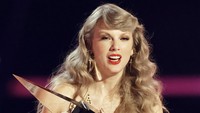 Taylor Swift kemudian naik ke panggung untuk menerima penghargaannya. Ia mengenakan pakaian panjang berwarna gold dengan rambutnya yang panjang bergelombang. Foto: Getty Images for dcp/Matt Winkelmeyer