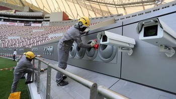 Pekerja memastikan sistem pendinginan ke lapangan bekerja dengan semestinya. Foto: AFP via Getty Images/KARIM JAAFAR