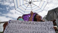 Warga korban penggusuran proyek Jakarta International Stadium (JIS) itu berkumpul di depan gerbang pintu masuk hunian Kampung Susun Bayam. Mereka mengenakan baju berwarna putih dan membawa sejumlah poster. 