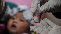 Tenaga kesehatan menunjukkan vaksin polio sebelum diberikan kepada seorang balita. Dikutip dari Central for Disease Control and Prevention (CDC AS), polio atau disebut poliomielitis, merupakan penyakit yang melumpuhkan dan mengancam jiwa.