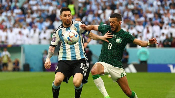 LUSAIL CITY, QATAR - NOVEMBER 22:   Lionel Messi of Argentina competes with Abdulelah Al-Malki of Saudi Arabia during the FIFA World Cup Qatar 2022 Group C match between Argentina and Saudi Arabia at Lusail Stadium on November 22, 2022 in Lusail City, Qatar. (Photo by Chris Brunskill/Fantasista/Getty Images)