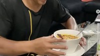 Ardi terlihat bersemangat saat makan ramen dengan camilan pistachio. Ia berterima kasih pada rekannya yang sudah mengirimkan makanan enak ini. 
