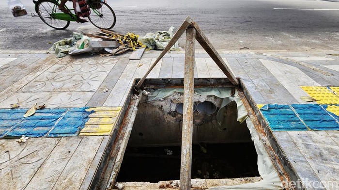 Got Trotoar di Jalan Agus Salim Belum Ditutup Warga melintas di jalur pedestrian dengan got yang belum ditutup dan hanya diberi penanda kayu di Jalan Agus Saloim, Jakarta Pusat, Selasa (22/11/2022). Proyek perbaikan trotoar yang masih menyisakan tutup got ini sudah berlangsung sejak beberapa hari lalu. Warga berharap got segera ditutup untuk keamanan dan kenyamanan pengguna jalur pedestrian. Foto diambil sekitar pukul 16.00 WIB.