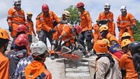 Tim penyelamat gabungan itu menggunakan alat untuk memecahkan semen dari bangunan yang runtuh akibat gempa.  