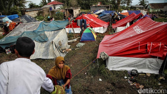 Sejumlah warga mengungsi di tanah kosong pinggir sawah di kawasan Desa Gasol, Kampung Lugewang, Cianjur, Jawa Barat, Selasa (22/11/2022). Menurut keterangan warga mereka masih membutuhkan logistik makanan minuman, air bersih, serta jenset untuk aliran listrik untuk koordinasi bantuan.