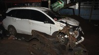 Sebuah mobil dan motor rusak usai dievakuasi dari timbunan longsor akibat gempa. (Eddy Purwanto/Getty Images)