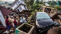 Selain menghancurkan bangunan, kerugian materil akibat gempa juga muncul dari mobil dan motor yang ringsek. (Aditya Aji/AFP/Getty Images)