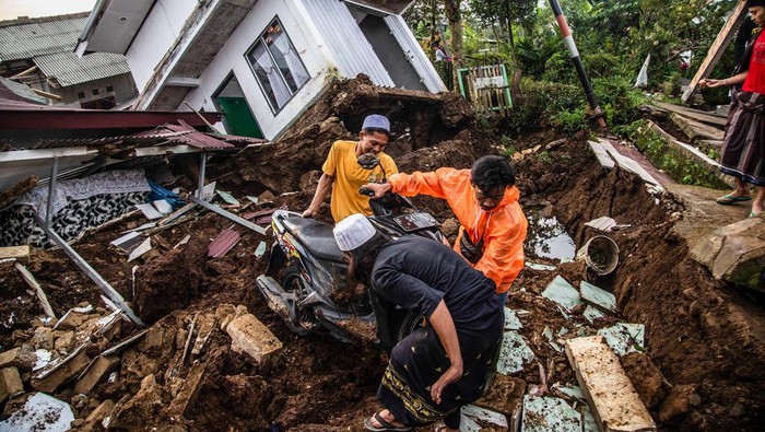 Villagers salvage items from damaged houses following a 5.6-magnitude earthquake that killed at least 162 people, with hundreds injured and others missing in Cianjur on November 22, 2022. (Photo by ADITYA AJI / AFP) (Photo by ADITYA AJI/AFP via Getty Images)