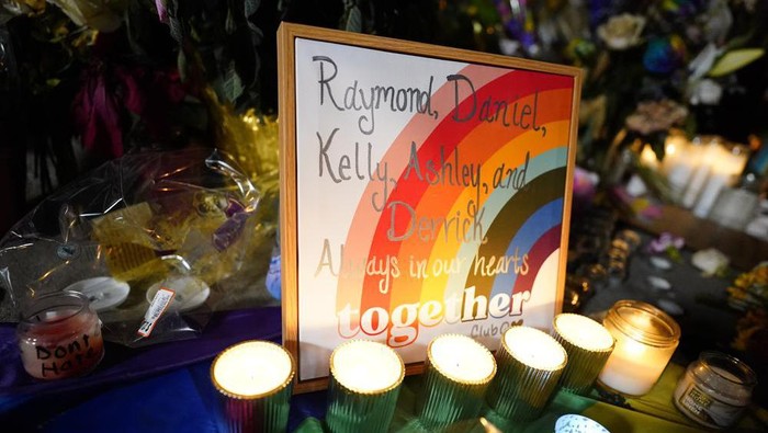 Names of the victims are shown on a rainbow during a candlelight vigil on a corner near the site of a weekend mass shooting at a gay bar, late Monday, Nov. 21, 2022, in Colorado Springs, Colo. (AP Photo/Jack Dempsey)