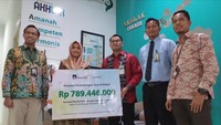 Hadir dalam penyerahan pencairan polis tersebut, Regional Sales Head Sharia PT AXA Mandiri Financial Services (AXA Mandiri) Yusuf Maulana bersama Area Manager Bank Syariah Indonesia (BSI) Banjarmasin Naning Salasatain menyerahkan klaim asuransi meninggal dunia kepada Novitasari, istri almarhum Abdul Aziz Kamarullah, nasabah AXA Mandiri, di Pangkalan Bun, Kalimantan Tengah, Selasa (22/11/2022). 