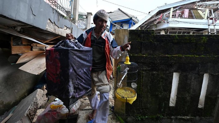 A man saves his pets following a 5.6-magnitude earthquake that killed at least 162 people, with hundreds injured and others missing in Cianjur on November 22, 2022. (Photo by ADEK BERRY / AFP) (Photo by ADEK BERRY/AFP via Getty Images)