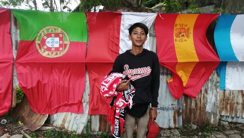 Pria asal Bandung, Farid Muhamad Ali Aridho (29), nekat pergi ke Bali untuk berjualan bendera peserta Piala Dunia. Ia berjualan di Jalan Raya Kuta, Badung, Bali, Selasa (22/11/2022).