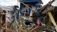 Seorang warga berusaha menyelamatkan barang yang masih tersisa dari reruntuhan rumah. Kemudian gedung perkantoran ada gedung BPBD, PUTR, Lapas Cianjur, Kejaksaan, Polres, KONI, Dinas Sosial, dan Kantor PCNU. Untuk masjid, ada Masjid Dekranasda, Masjid Desa Bonjot, dan Masjid Desa Cikancana. (Adek Berry/AFP/Getty Images)