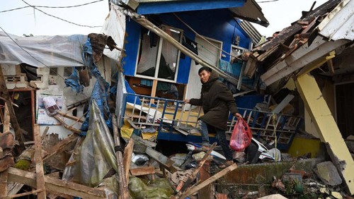 A man salvages items from a damaged house following a 5.6-magnitude earthquake that killed at least 162 people, with hundreds injured and others missing in Cianjur on November 22, 2022. (Photo by ADEK BERRY / AFP) (Photo by ADEK BERRY/AFP via Getty Images)