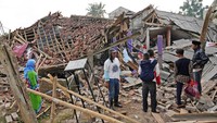 Orang-orang memeriksa reruntuhan bangunan yang terdampak gempa di Cianjur. Badan Penanggulangan Bencana Daerah (BPBD) melaporkan data kerusakan infrastruktur dan bangunan, imbas dari gempa bumi berkekuatan 5,6 M yang melanda Kabupaten Cianjur Senin kemarin. (AP Photo/Tatan Syuflana)