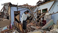 Warga melihat kondisi rumah yang runtuh akibat gempa Cianjur. Tidak hanya kerusakan infrastruktur, BPBD turut melaporkan sebanyak 162 orang meninggal dunia dan 326 orang luka-luka. Total ada sebanyak 13.784 orang warga yang kini mengungsi. Seperti diberitakan sebelumnya, Senin (21/11) kemarin terjadi gempa bumi yang berpusat di 10 km barat daya Kabupaten Cianjur, Jawa Barat. Gempa berkekuatan 5,6 M ini terjadi tepat pukul 13.21. (AP Photo/Tatan Syuflana)