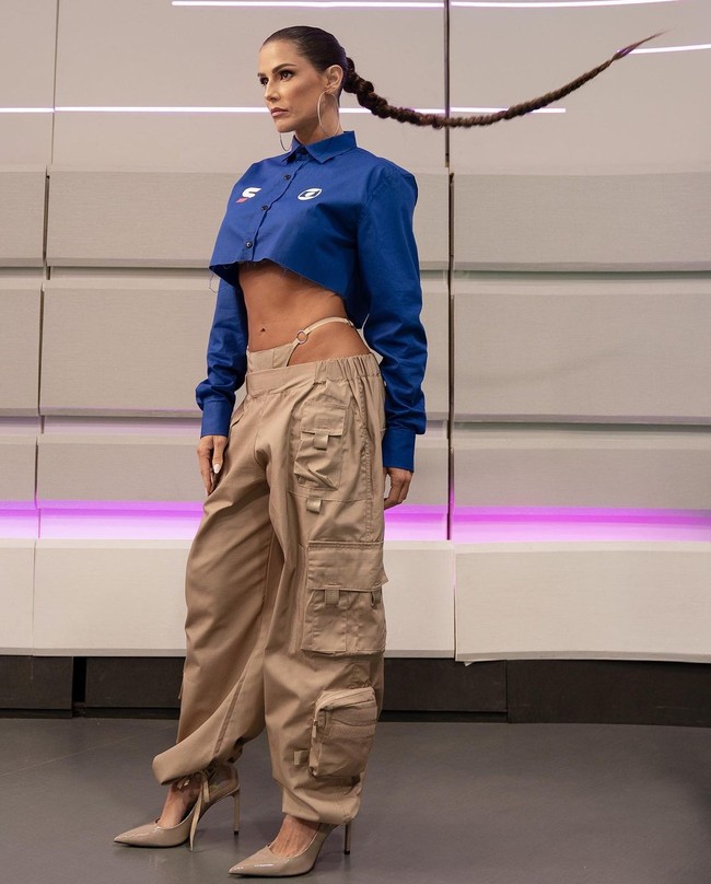 Selagi membawakan acara Piala Dunia 2022 di stasiun SporTV, Deborah hampir selalu tampil dengan atasan bernuansa biru seperti jersey timnas Brasil sebagai bentuk dukungan pada negara. Tapi styling-nya dianggap terlalu vulgar. Misalnya ketika memakai kemeja yang mengekspos bagian perut ini.Foto: Instagram @dedesecco