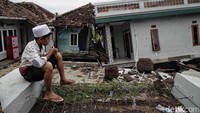 Seorang bocah duduk di reruntuhan bangunan yang hancur akibat gempa.