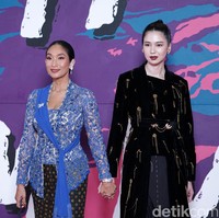 Duo Happy Salma dan Laura Basuki dari film Nana tampil bersama di karpet merah FFI 2022. Kebaya klasik biru dengan aksen selendang karya Biyan menjadi andalan Happy, sementara Laura bersolek dengan busana gelap dari Tangan Official. (Foto: Palevi S/detikFoto)