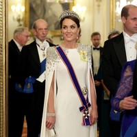 Aura seorang putri makin terpancar dengan balutan gaun putih beraksen cape dan taburan kristal dan sequin di bahu karya Jenny Packham. Sebagai seorang royal, ibu tiga anak ini juga memakai selempang kerajaan berwarna ungu. Foto: Chris Jackson/Getty Images