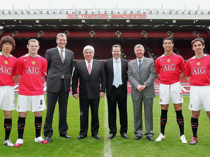 MANCHESTER, ENGLAND - APRIL 6: David Gill of Manchester United poses with Martin Sullivan, CEO of AIG, Sir Alex Ferguson, Bryan Glazer, Ji-Sung Park, Wayne Rooney, Cristiano Ronaldo and Gary Neville after the press conference to announce the club's new shirt sponsors at Old Trafford on April 6 2006, in Manchester, England. (Photo by John Peters/Manchester United via Getty Images)