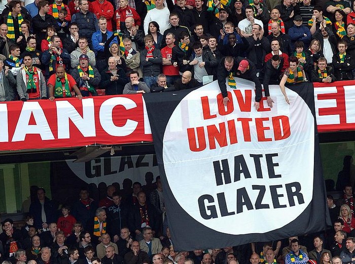 Manchester United supporters hold anti-Glazer family banners during their English Premier League football match against Liverpool at Old Trafford in Manchester, north-west England, on March 21,2010. AFP PHOTO/PAUL ELLIS - FOR EDITORIAL USE ONLY Additional licence required for any commercial/promotional use or use on TV or internet (except identical online version of newspaper) of Premier League/Football League photos. Tel DataCo +44 207 2981656. Do not alter/modify photo. (Photo credit should read PAUL ELLIS/AFP via Getty Images)