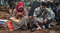 Warga berdoa di tengah reruntuhan tanah longsor di Desa Cijedil, Kecamatam Cugenang, Cianjur, Jawa Barat, Rabu (23/11/2022).
