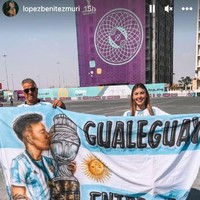 Melalui unggahan di Instagram Story, Muri Lopez Benitez memperlihatkan momen dirinya berada di Qatar untuk menonton pertandingan perdana Argentina di Piala Dunia 2022. Dia berpose sambil membentangkan spanduk bergambar wajah kekasihnya, Lisandro Martinez. Foto: Dok. Instagram @lopezbenitezmuri