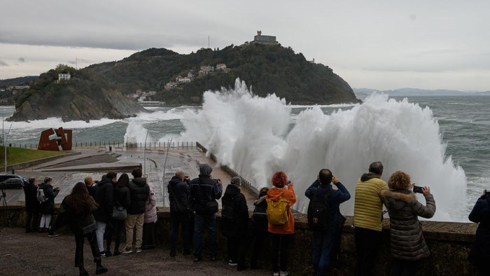 Meskipun berbahaya, warga maupun wisatawan sangat antusias mengambil foto saat ombak besar menghantam tembok di pesisir pantai di San Sebastian. Nih fotonya.
