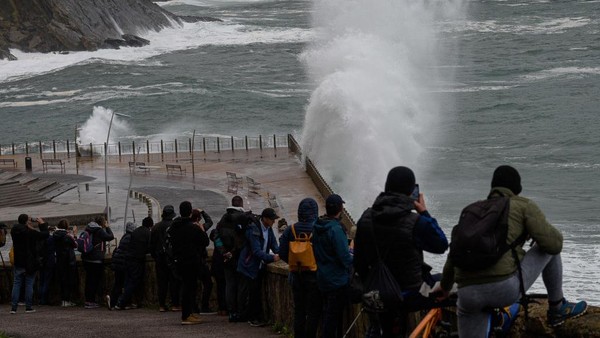 Sejumlah warga menyaksikan gelombang ombak yang menghantam pesisir pantai di San Sebastian, Negara Basque, Spanyol, Selasa (22/11/2022).