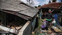 Sebagian warga mengevakuasi barang-barangnya dari reruntuhan bangunan rumah.