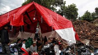 Tenda darurat itu didirikan di sekitar bangunan yang ambruk.