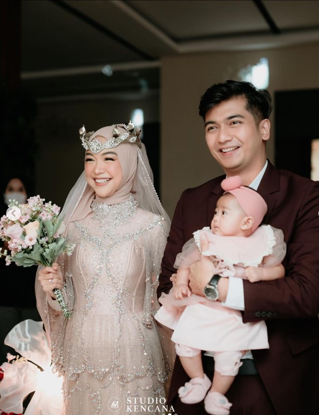 Ria Ricis sendiri tampil cantik dalam balutan gaun berwarna coklat karya desainer Lucky Hakim. Penampilannya itu dilengkapi dengan aksesori seperti mahkota di atas kepalanya. Tampil bak pengantin wanita, Ricis juga membawa sebuah hand bouquet di tangannya. Foto: Instagram/@studiokencana