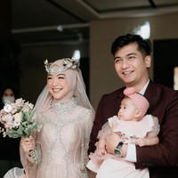 Ria Ricis sendiri tampil cantik dalam balutan gaun berwarna coklat karya desainer Lucky Hakim. Penampilannya itu dilengkapi dengan aksesori seperti mahkota di atas kepalanya. Tampil bak pengantin wanita, Ricis juga membawa sebuah hand bouquet di tangannya. Foto: Instagram/@studiokencana