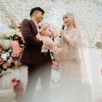 Sementara sang suami, Teuku Ryan tampil gagah mengenakan setelan jas berwarna marun. Kebahagiaan keduanya tentu kini semakin lengkap dengan kehadiran sang buah hati yang turut diajak menghadiri perayaan anniversary Ricis dan Ryan. Foto: Instagram/@studiokencana