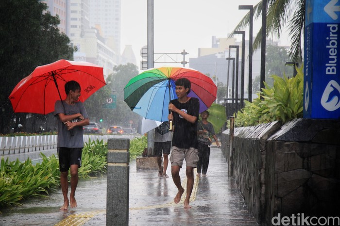 Para ojek payung menawarkan jasa saat hujan deras di kawasan Bundaran HI, Jalan MH Thamrin Jakarta