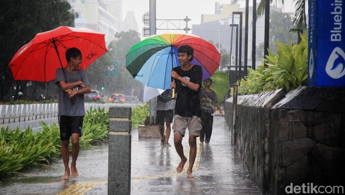 Para ojek payung menawarkan jasa saat hujan deras di kawasan Bundaran HI, Jalan MH Thamrin Jakarta